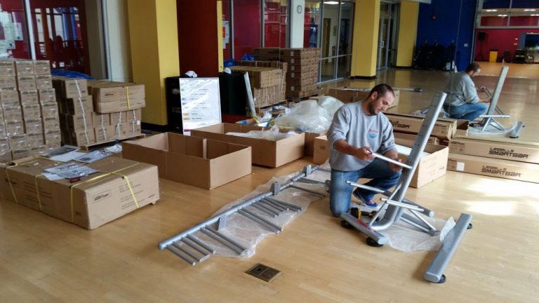 Gym room. Mover assembling gym equipment