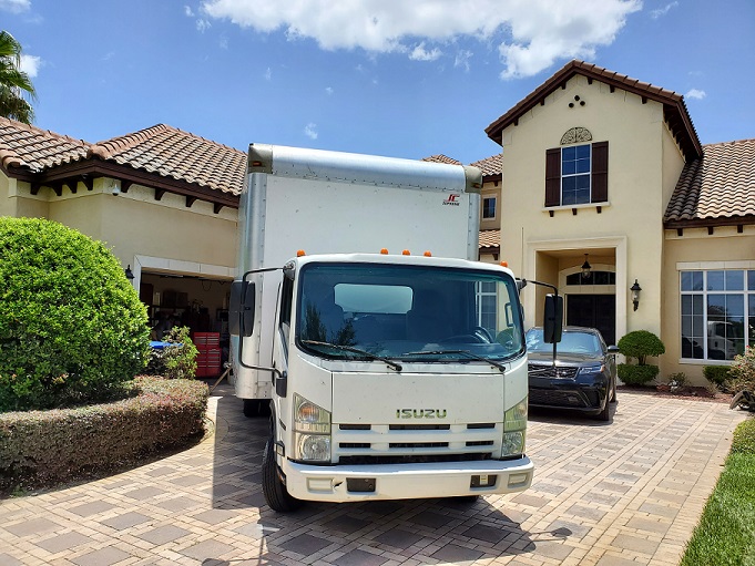Moving truck in bay hill house driveway.