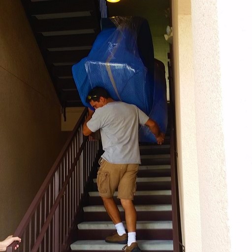 Large staircase. Movers getting the couch down the stairs.