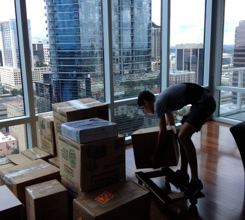 Highrise apartment seeing orlando downtown.Pro mover loading boxes on a 4 wheeler dolly.