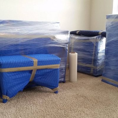 Bedroom area with packed into blankets and wrap furniture .Moving company Orlando
